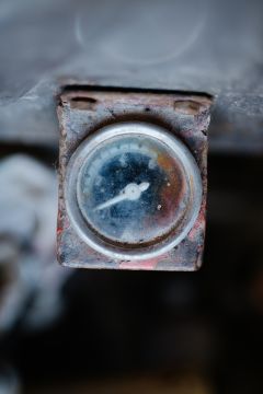 File:Old pressure gauge showing measurements in a worn condition located in a workshop.jpg